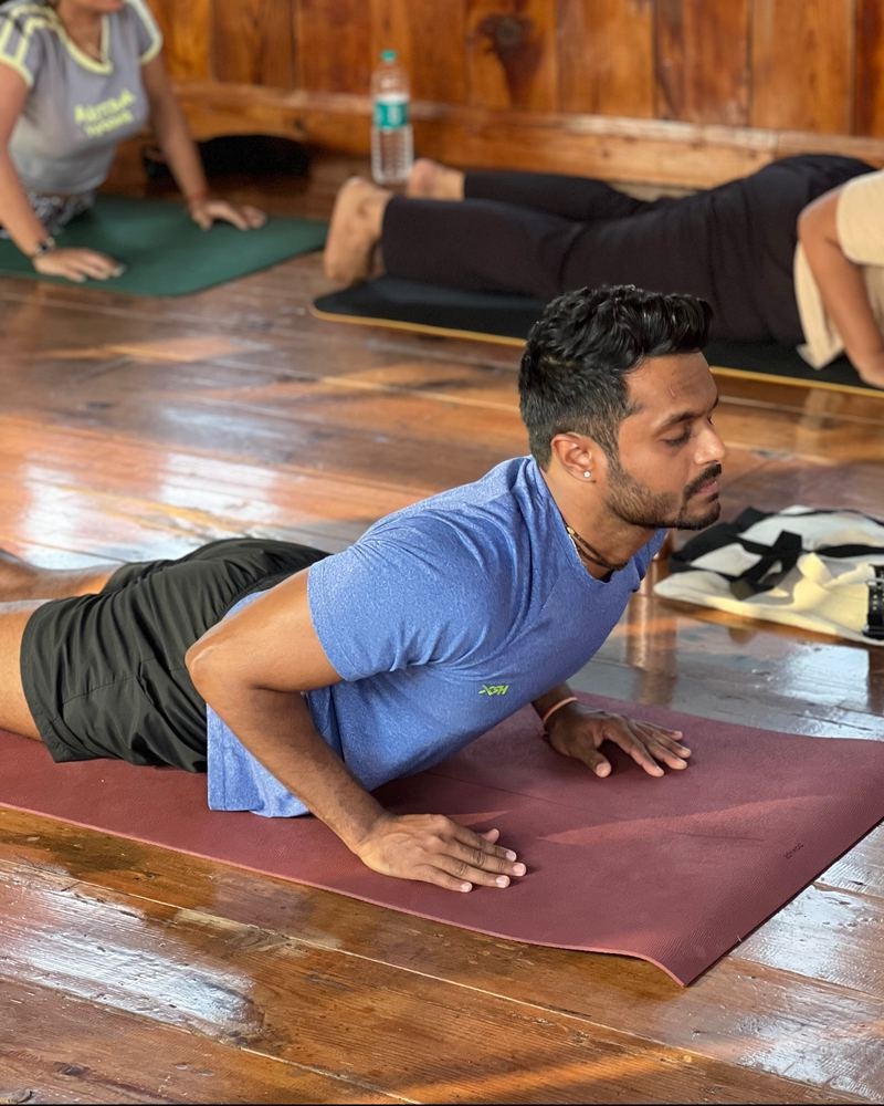 Prathamesh Chavan practising a backbend alongside students in a class